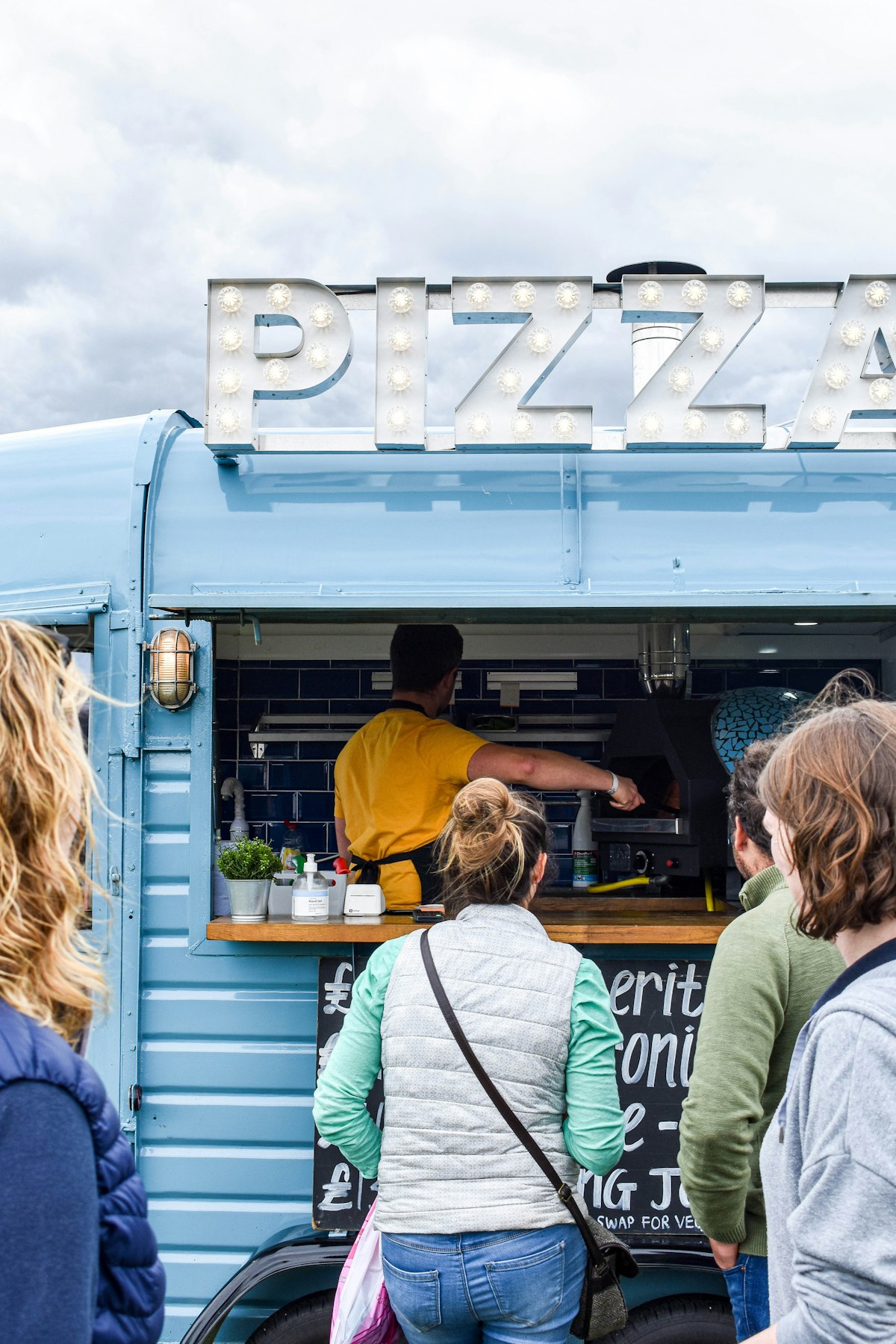 Bezoekers eten bij foodtrucks tijdens een festival